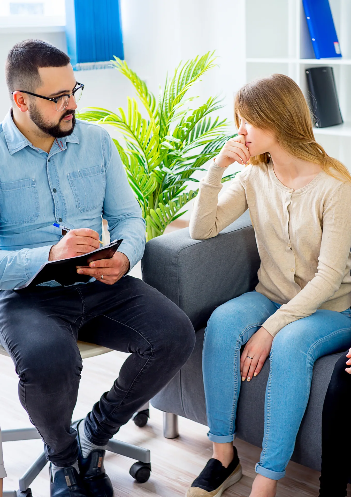 Beratungsgespräch in einer modernen Kinder- & Jugendhilfeeinrichtung, Therapeut spricht empathisch mit Jugendlichen, fördert Unterstützung und positives Wohlbefinden in freundlicher Atmosphäre.