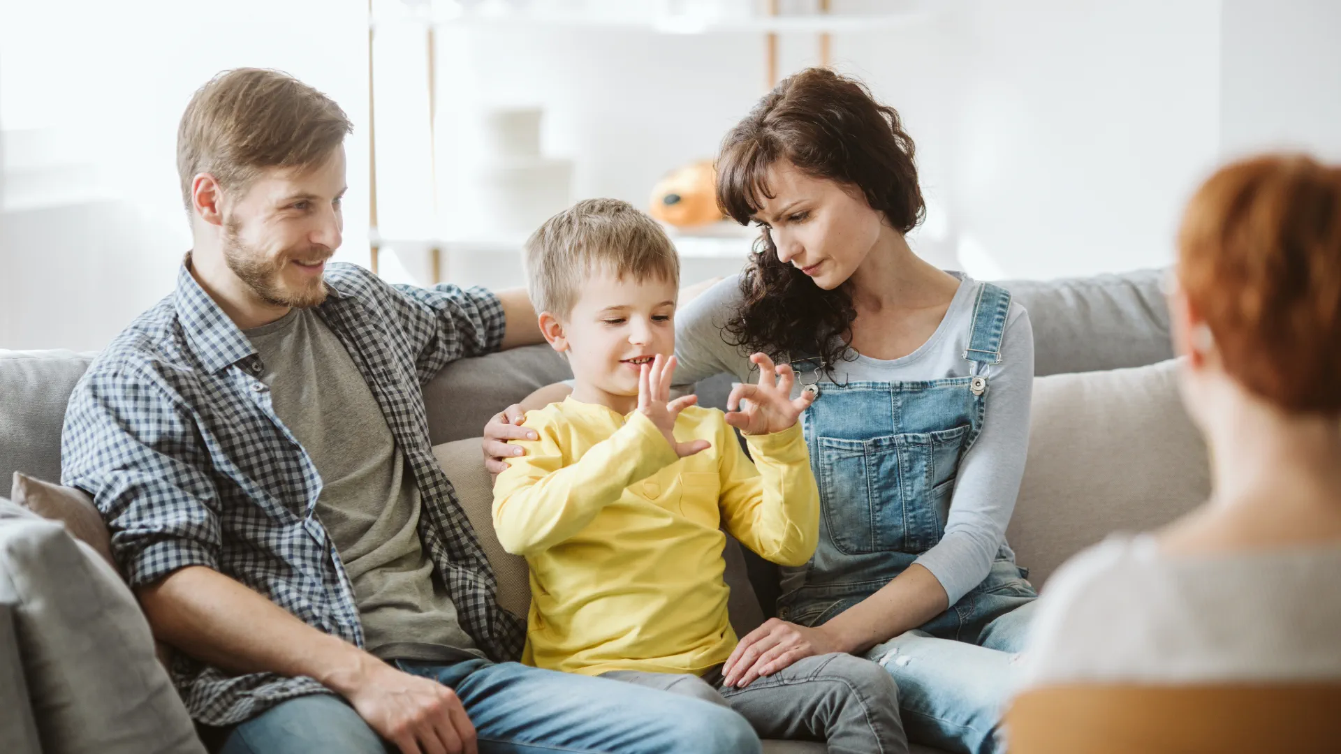 Eine Mutter unterstützt ihr Kind beim Lernen zu Hause in einer freundlichen Kinder- & Jugendhilfeeinrichtung, beide wirken glücklich und in einem positiven Umfeld.