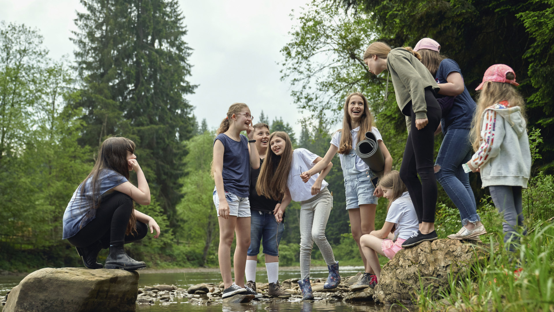 Gruppe fröhlicher Kinder und Jugendlicher bei einem Ausflug in der Natur, organisiert von einer modernen Kinder- & Jugendhilfeeinrichtung, fördert Gemeinschaft und Abenteuerlust.